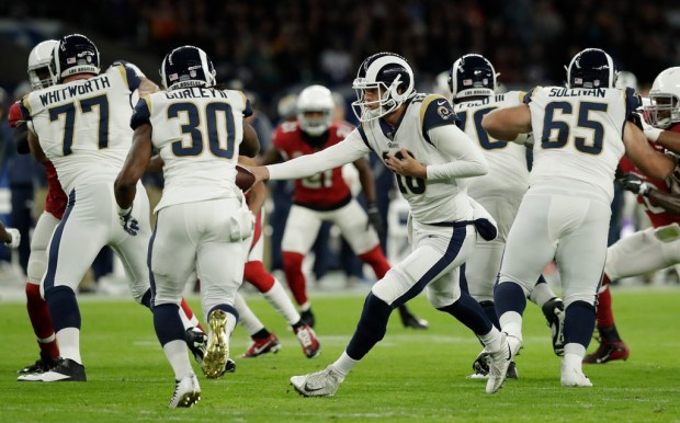 As Rams running back Todd Gurley (30) takes a hand off from Jared Goff, a hole opens thanks to Andrew Whitworth (77, left), Rodger Saffold and, far right,John Sullivan during the game against Arizona at Twickenham Stadium in London on Oct. 22. (AP Photo/Matt Dunham) Matt Dunham